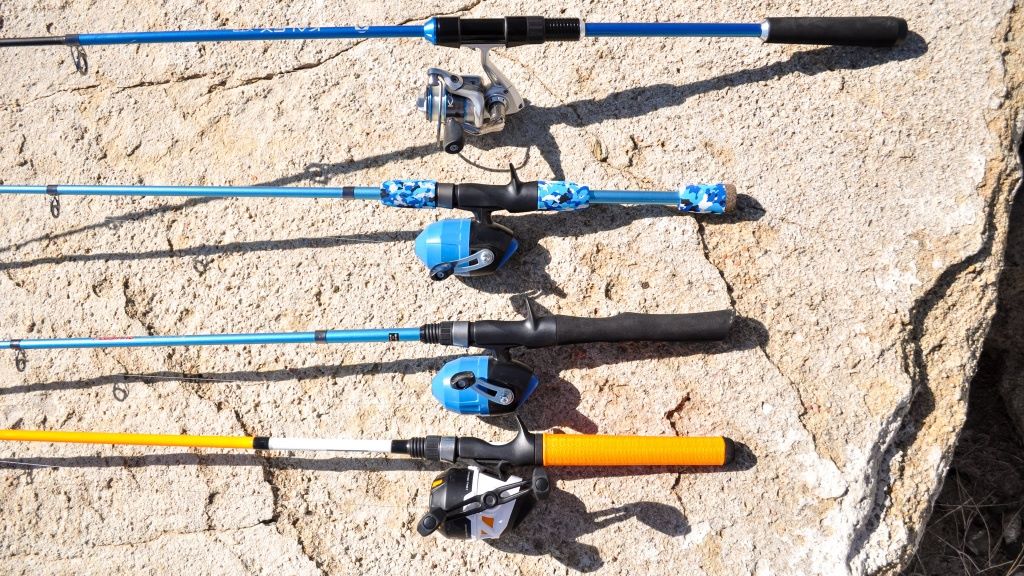 Child holding fishing gear including bait, hooks, and beginner rod