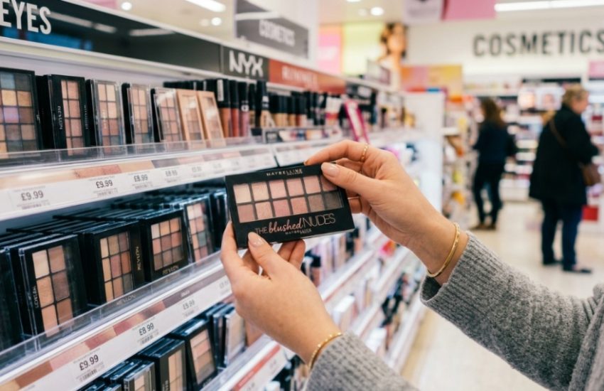 Affordable eyeshadow palettes and makeup brushes arranged on a sunny pastel surface.